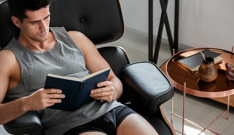 a man sitting in a chair reading a book